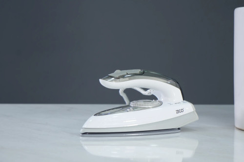 اتو مسافرتی ZC-2055 در حال بخاردهی روی پیراهن مردانه